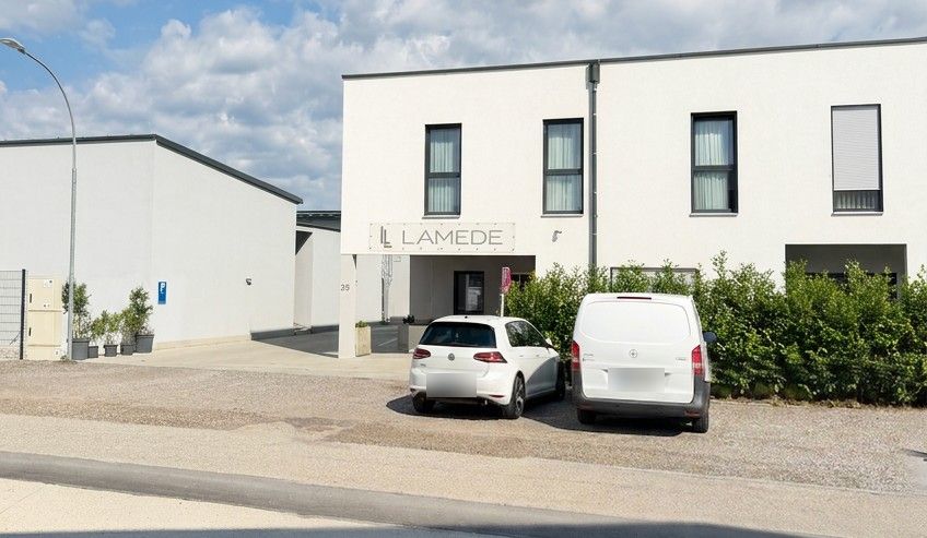 Hotel Lamede seen from the street, with parking spaces in front of the house